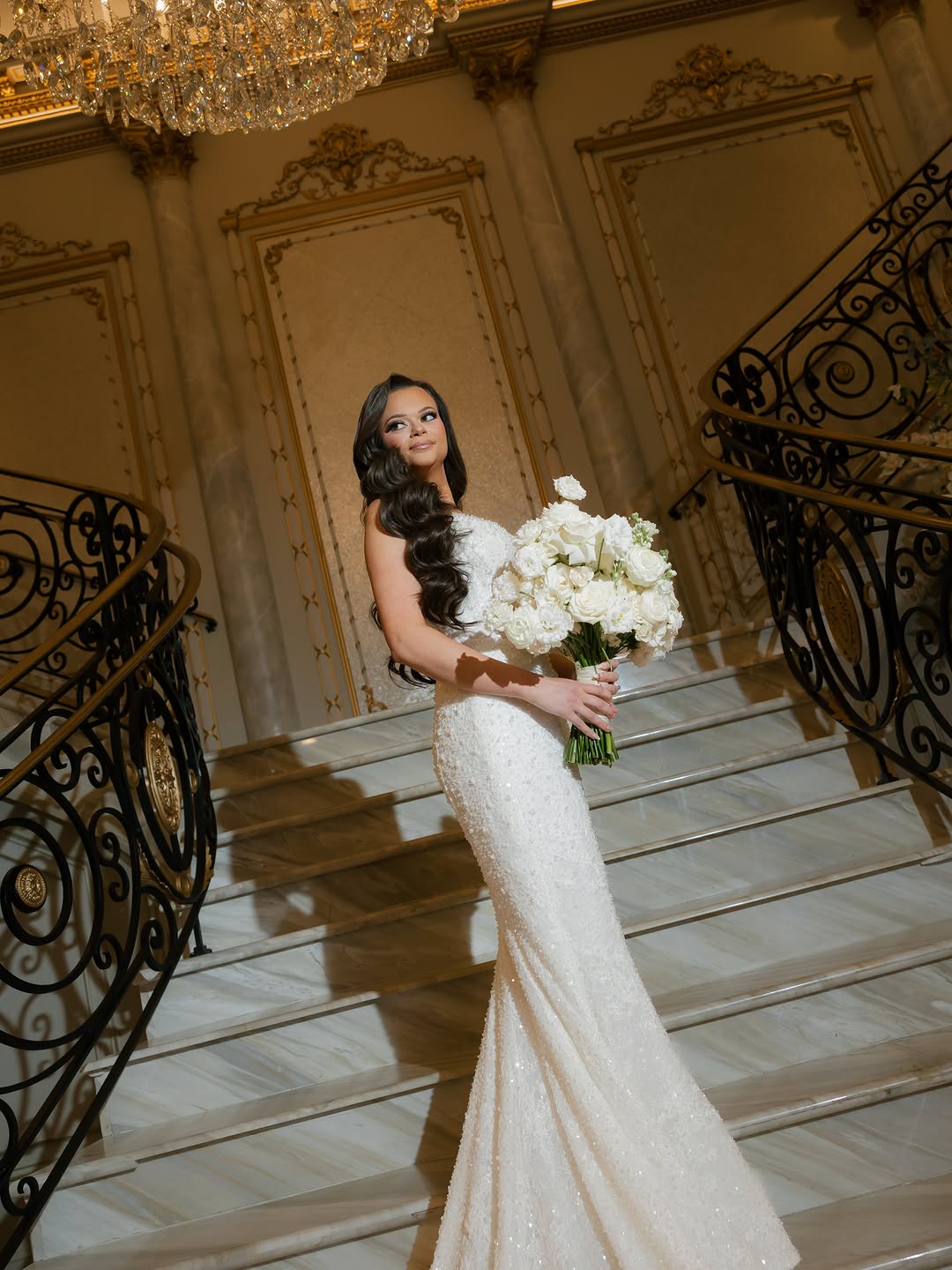 Bride with white florals beneath the chandelier