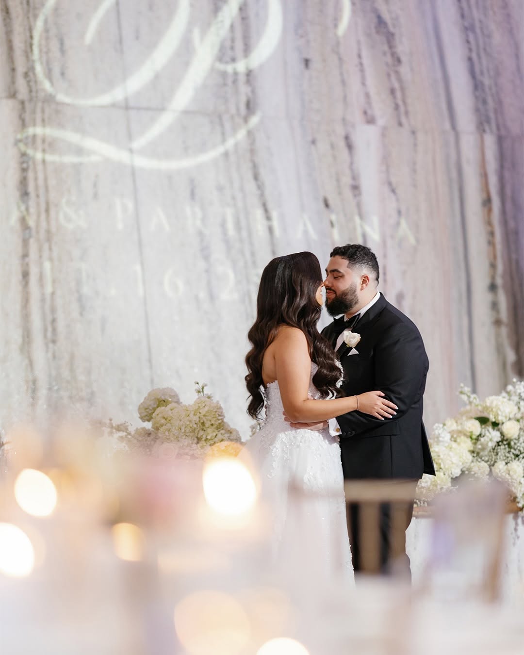 First kiss at a white floral altar